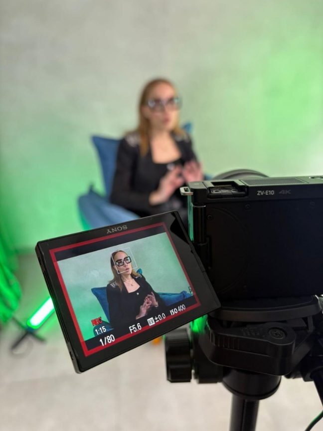 Câmera da CDC gravando entrevista em cenário com iluminação verde